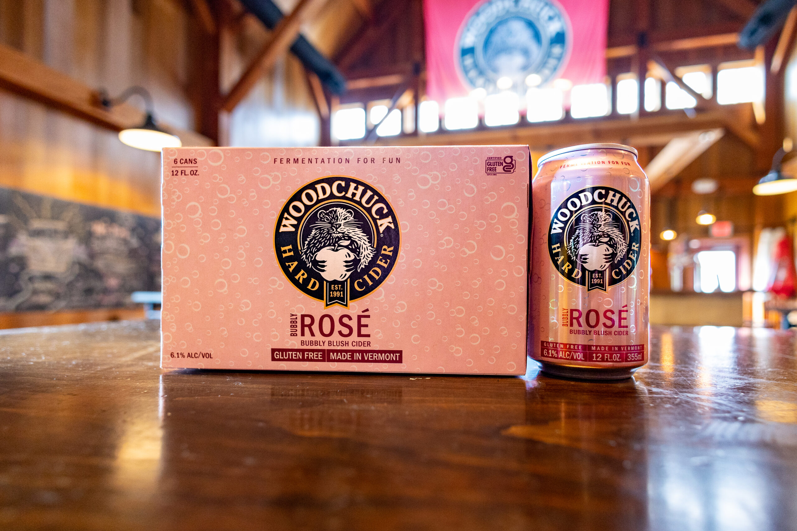 Woodchuck Bubbly Rosé Hard Cider - Bubbly Blush Cider 12 oz can next to a 6 pack