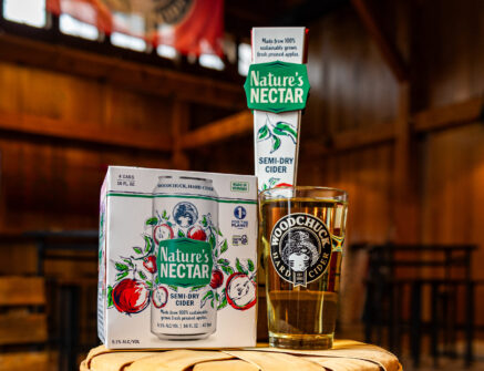Nature's Nectar hard cider 4 pack, tap handle and glass with the Woodchuck Hard Cider logo.